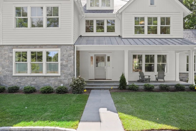 Enviroshake composite roofing on a white farmhouse-style home with a covered front porch