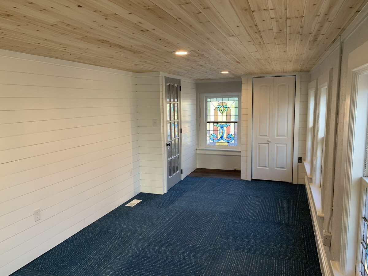 Finished basement with shiplap walls and wood ceiling